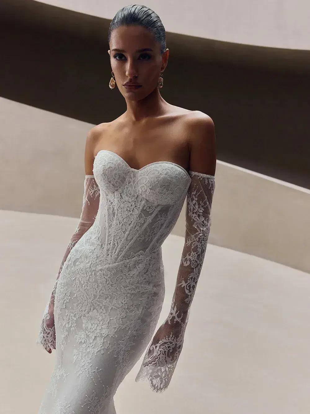 model is wearing an off the shoulder lace bridal gown